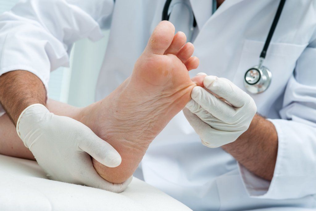 Medirval médico revisando pies a persona